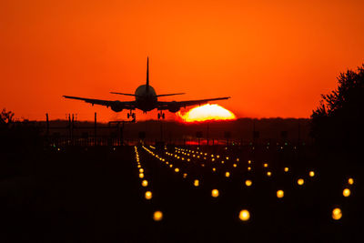 Low angle view of silhouette airplane against sky during sunset