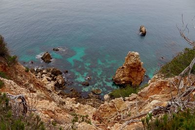 High angle view of rocks on sea shore