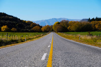 Road leading towards mountain against sky