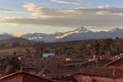 Aerial view of townscape and mountains against sky