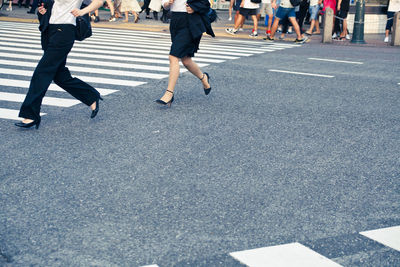 Low section of people walking on road