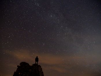 Silhouette man standing against star field at night