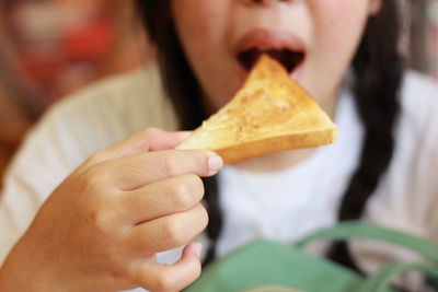 Close-up of woman eating bread