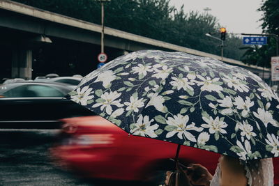 Woman holding umbrella on street during monsoon