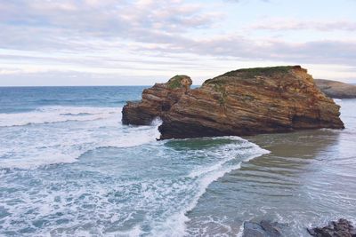 Rocks in sea against sky