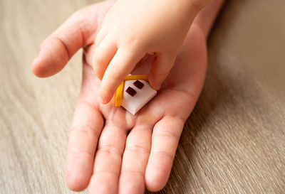 Cropped hand of person holding toy blocks on table