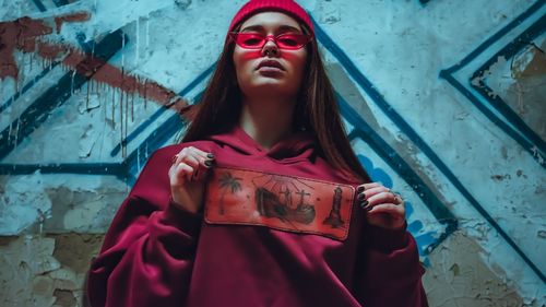 Portrait of woman standing against wall