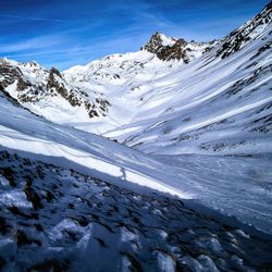 Scenic view of snowcapped mountains against blue sky