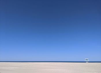 Scenic view of beach against clear blue sky