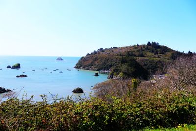 Scenic view of sea and mountains against clear sky