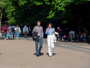 Rear view of people walking by trees