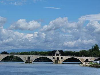 Arch bridge over river against sky