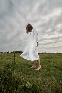 Woman standing on field against sky