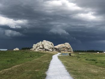 Built structure on land by road against sky