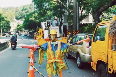 Mannequin with helmet on road by traffic cones