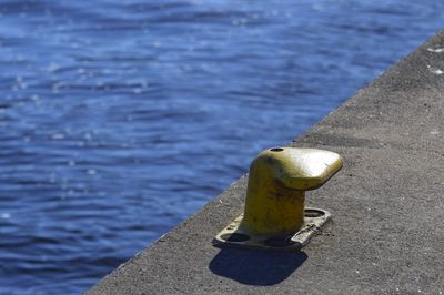 High angle view of bollard on pier over sea