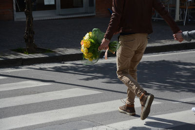 Low section of man walking on road