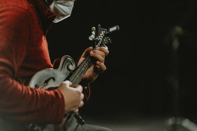 Man with face mask playing mandolin