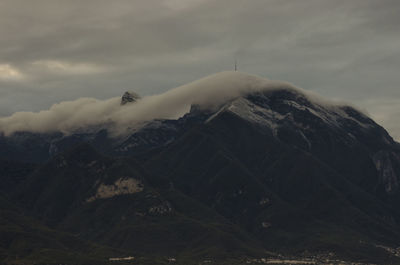 Scenic view of mountains against cloudy sky