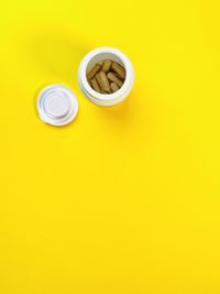 High angle view of tea cup on yellow table