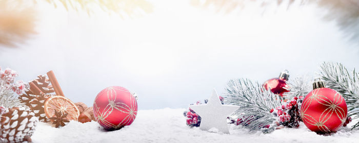 Christmas decorations on snow covered land against sky