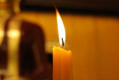 Close-up of lit candle in temple