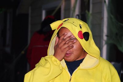 Close-up of man wearing yellow hood at night