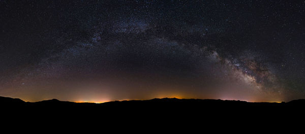 Scenic view of silhouette mountain against star field at night