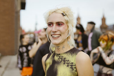 Happy non-binary person with make-up on face