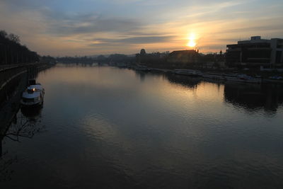 Reflection of buildings in river during sunset