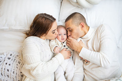 High angle view of family with newborn child on bed