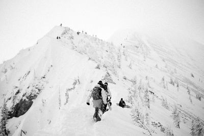 Tourists on snow covered mountain