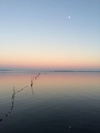 Scenic view of lake against clear sky at sunset