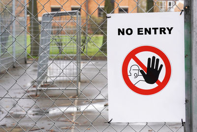 Close-up of warning sign on fence
