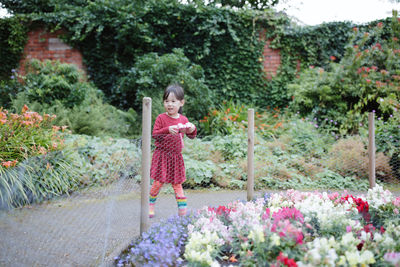 Young girl taking photo in the summer garden morning