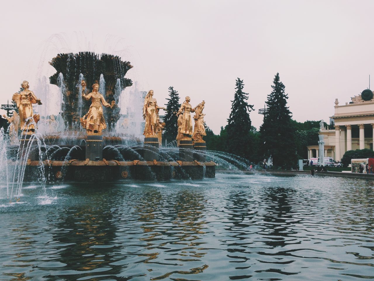 water, architecture, building exterior, built structure, waterfront, clear sky, fountain, motion, splashing, wet, reflection, building, copy space, incidental people, outdoors, day, spraying, rippled, travel destinations, river