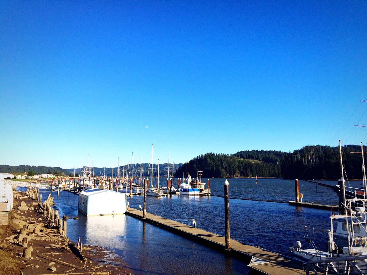 clear sky, water, copy space, blue, nautical vessel, sea, built structure, transportation, architecture, moored, boat, building exterior, mode of transport, tranquility, harbor, tranquil scene, nature, day, scenics, river