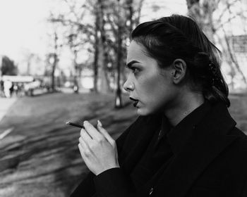 Woman looking away while smoking cigarette