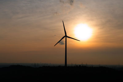 Silhouette windmill against sky during sunset