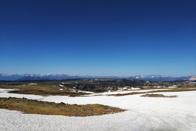 Scenic view of snowcapped mountains against clear blue sky