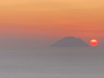 Scenic view of landscape against orange sky