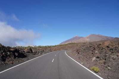 Road amidst landscape against blue sky