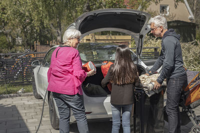 Grandparents with granddaughter loading car