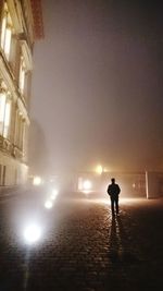 Full length of woman walking on illuminated street light at night