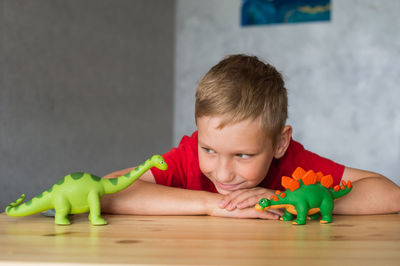 There are two dinosaur toys in children's hands