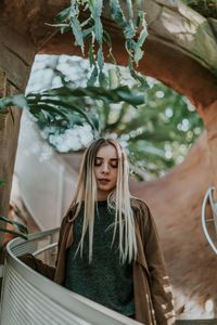 Woman looking down while standing at park