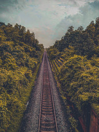 Railroad tracks by trees against sky