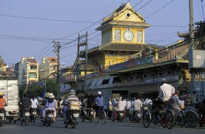 People on street by buildings in city