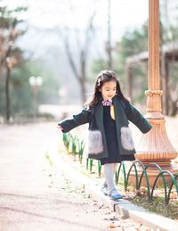 Portrait of smiling girl on curb