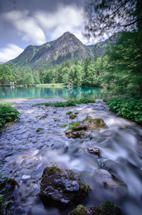 Scenic view of river amidst mountains against sky